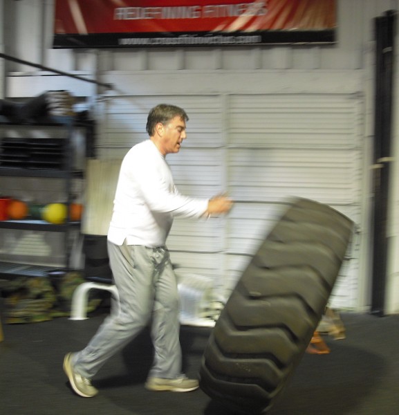 Harvey of CrossFit Invictus San Diego Harvey bowling with tires